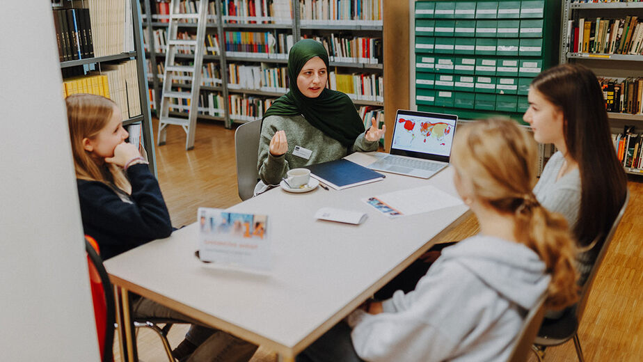 Experting spricht mit Schüler*innen in der C3-Bibliothek