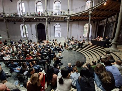 Menschen sitzen in einem großen Veranstaltungsraum